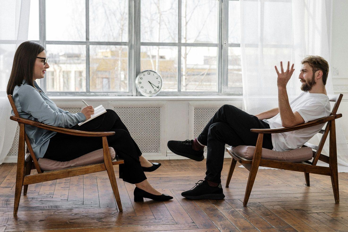 Mann mit Tinnitus im Gespräch mit einer Psychotherapeutin