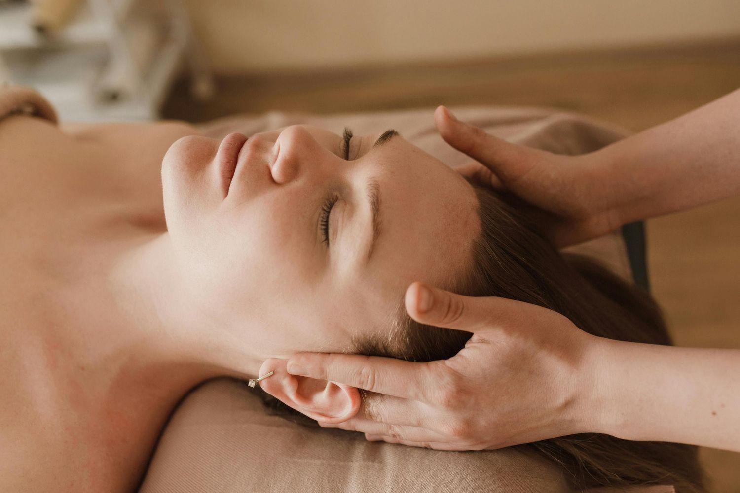 Nahaufnahme von einer Frau, die gerade eine Ohr-Massage bekommt, um besser zu hören.