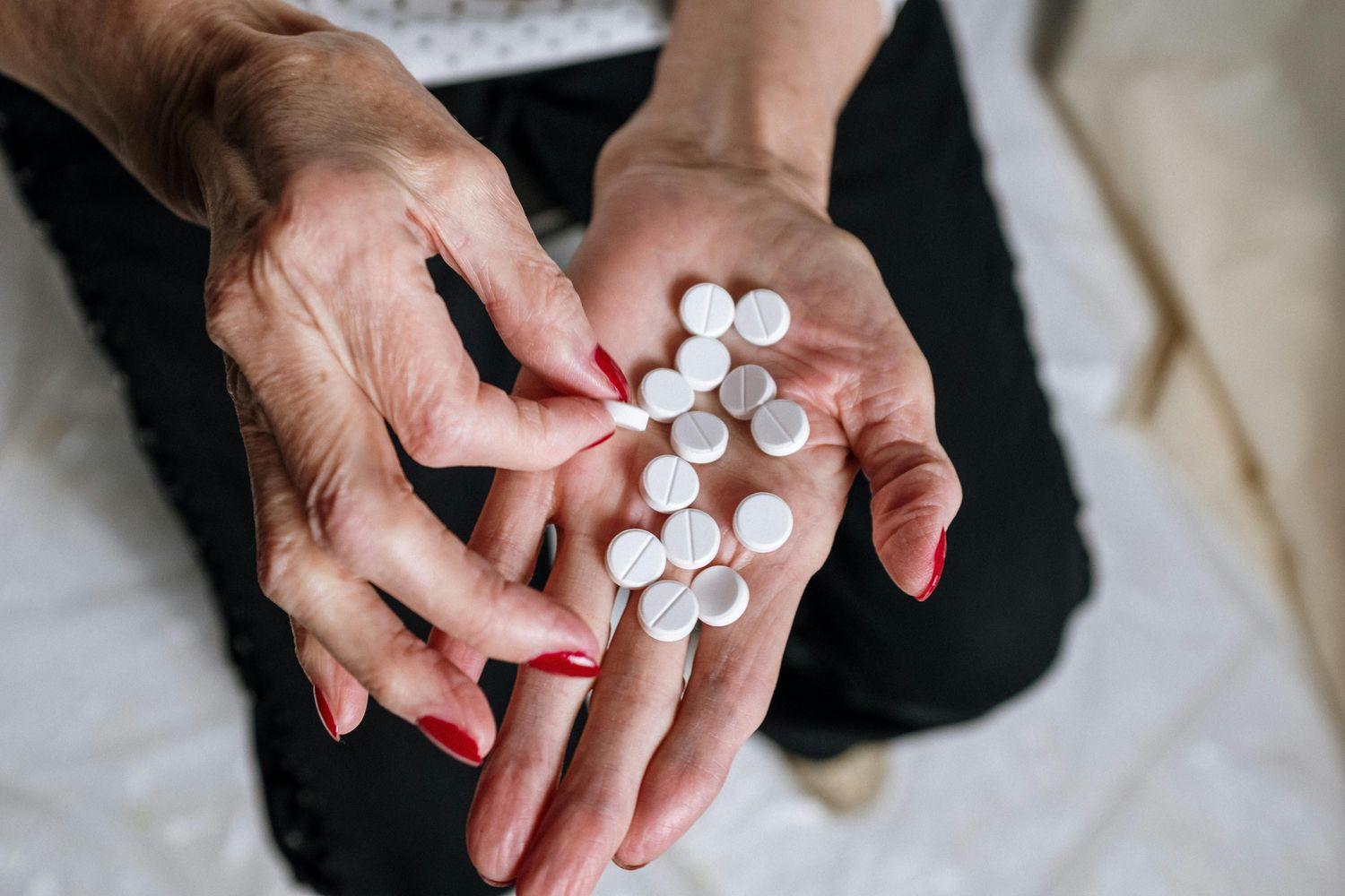 Eine Frau, die weiße Pillen in der Hand hält
