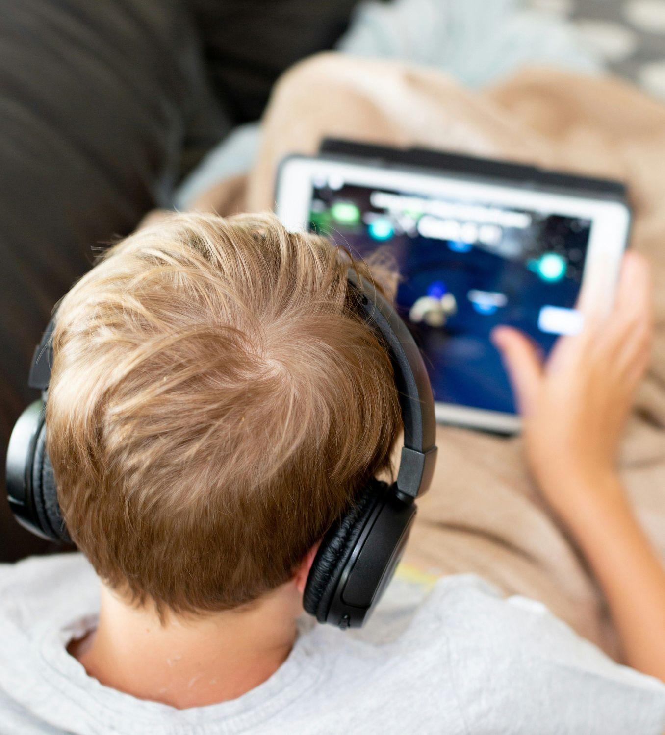 Ein Kind mit Hörsturz-Symptomen macht einen Online-Hörtest am Laptop