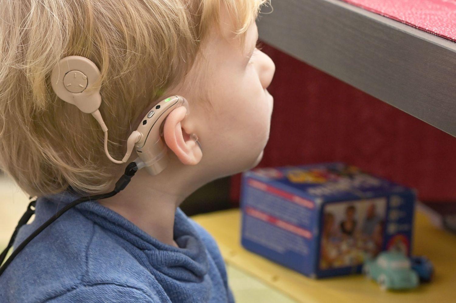 Nahaufnahme von einem kleinen Jungen, der ein Cochlea Implantat trägt.