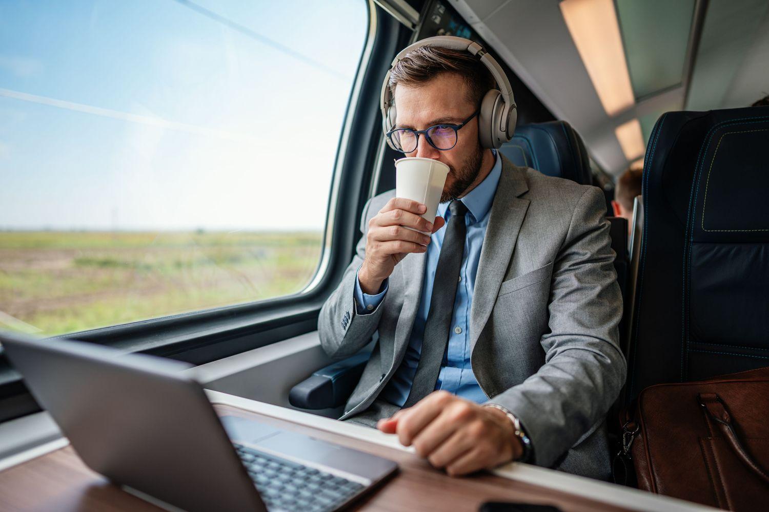 Mann im Zug mit Noise-Cancelling-Kopfhörern zur Geräuschunterdrückung