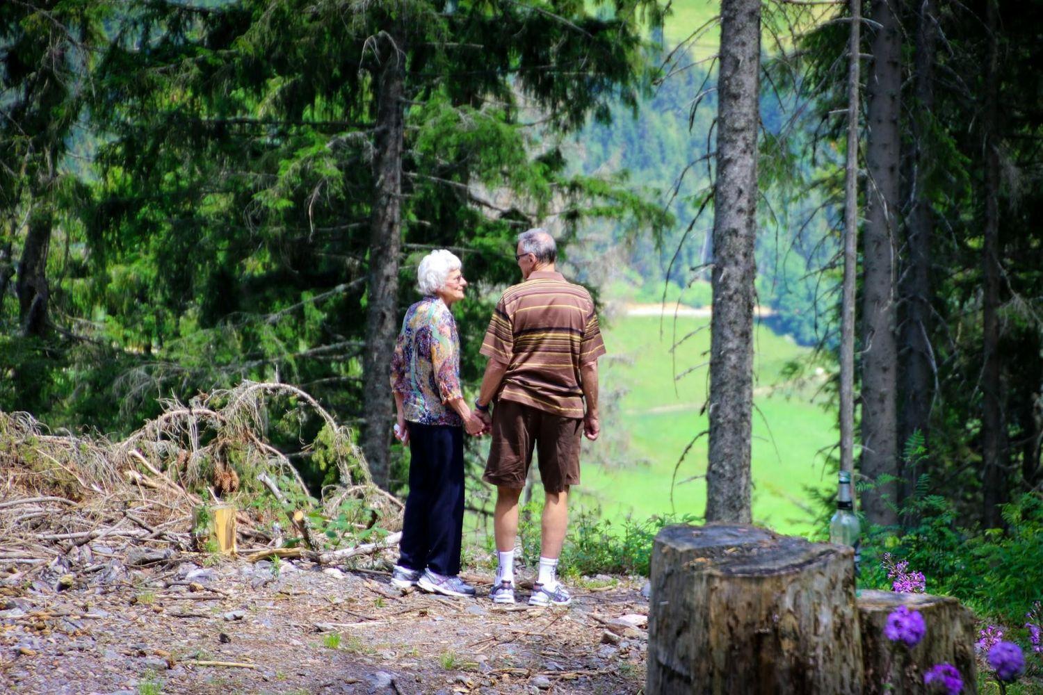 Paar mit Altersschwerhörigkeit geht im Wald spazieren
