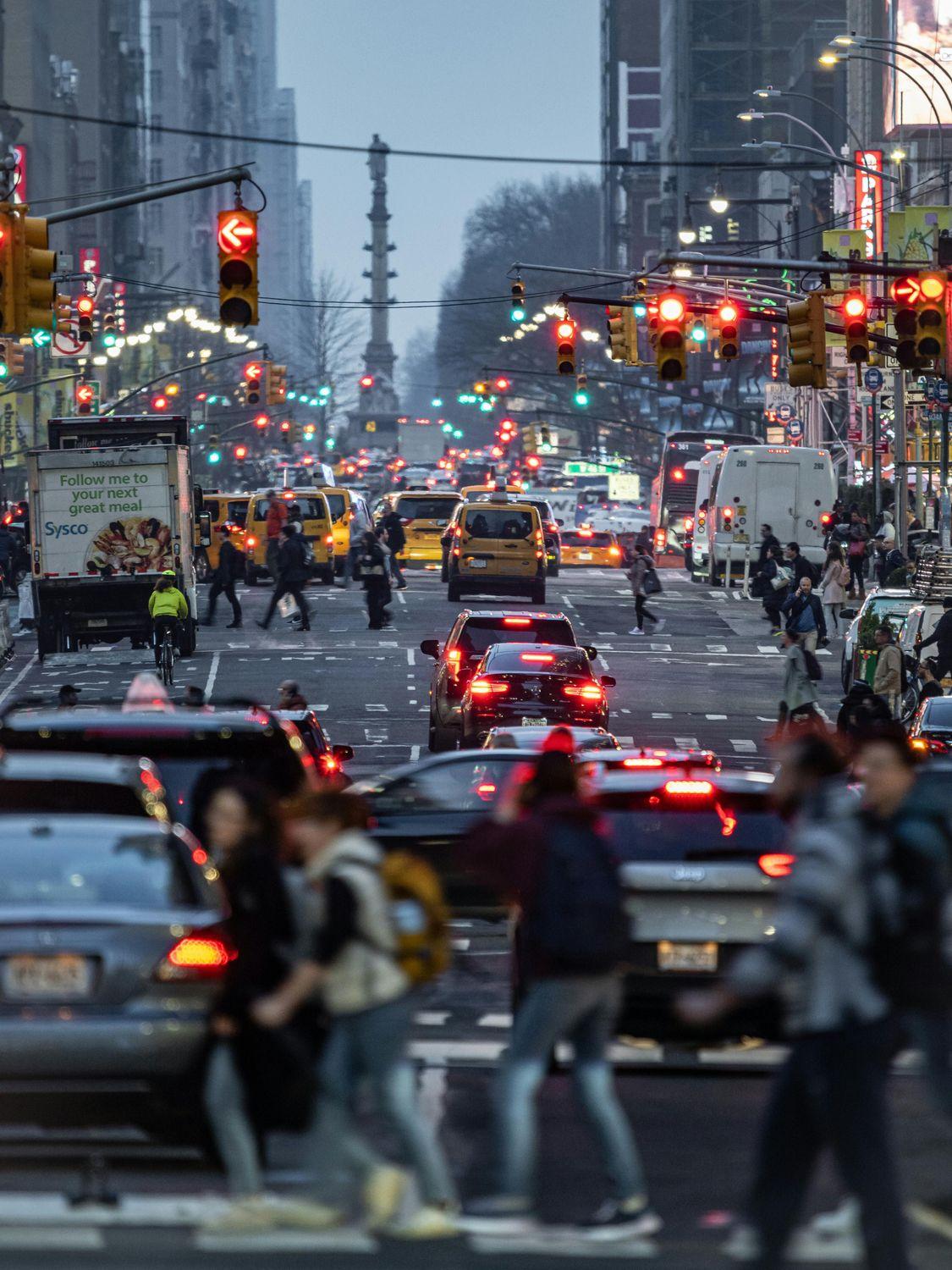 Eine Straße mit starkem Verkehr in einer Stadt mit vielen Menschen